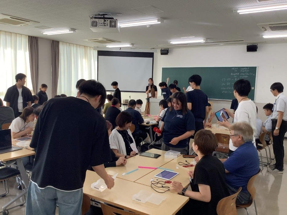 スタッフと交流しながらグループで作品を作る参加者たち